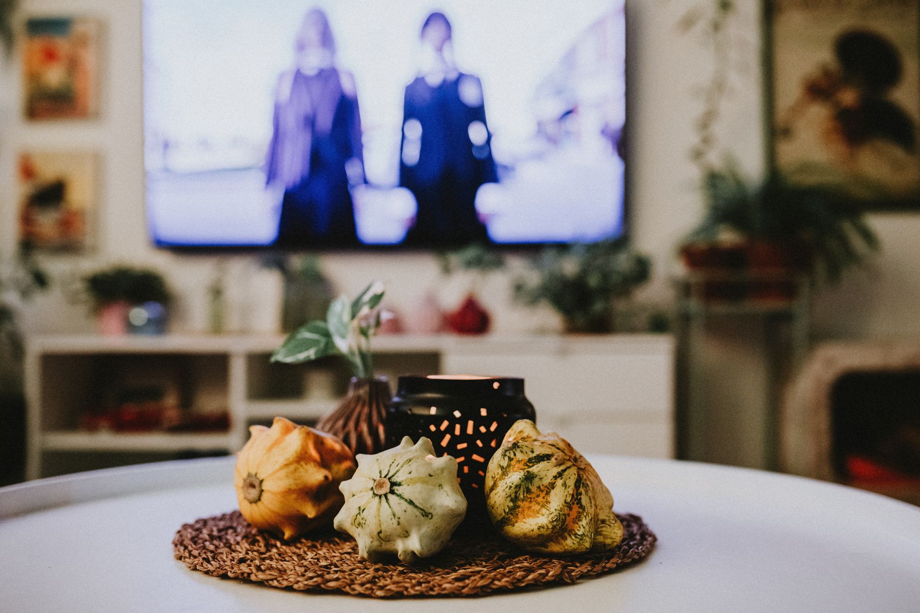 Jesienne dekoracje na stole przed włączonym telewizorem